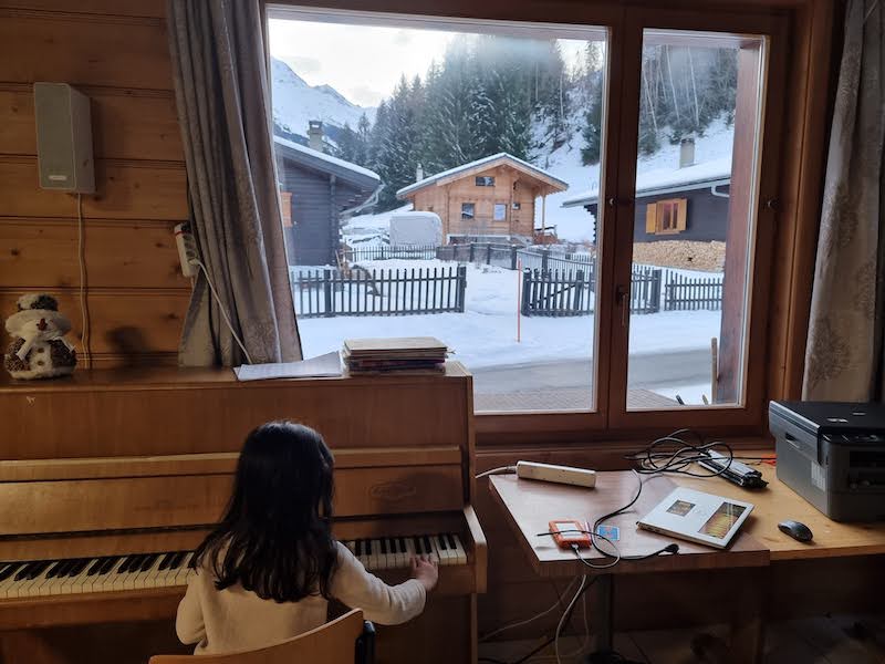 The piano and view at Ski Hostel Liddes in Switzerland
