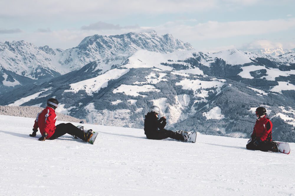 Snowboarders relax and enjoy the view during a ski holiday in austria